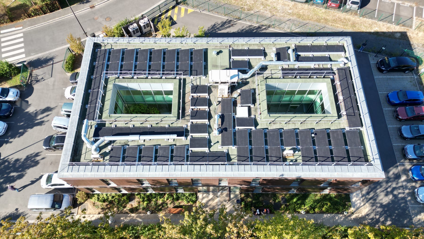 Vue aérienne du Pôle Ophtalmo Melun : toiture couverte de panneaux photovoltaïques et deux patios végétalisés